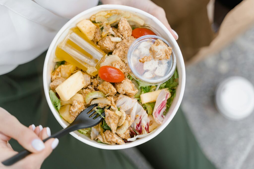 A Person Holding Cooked Food on White Bowl